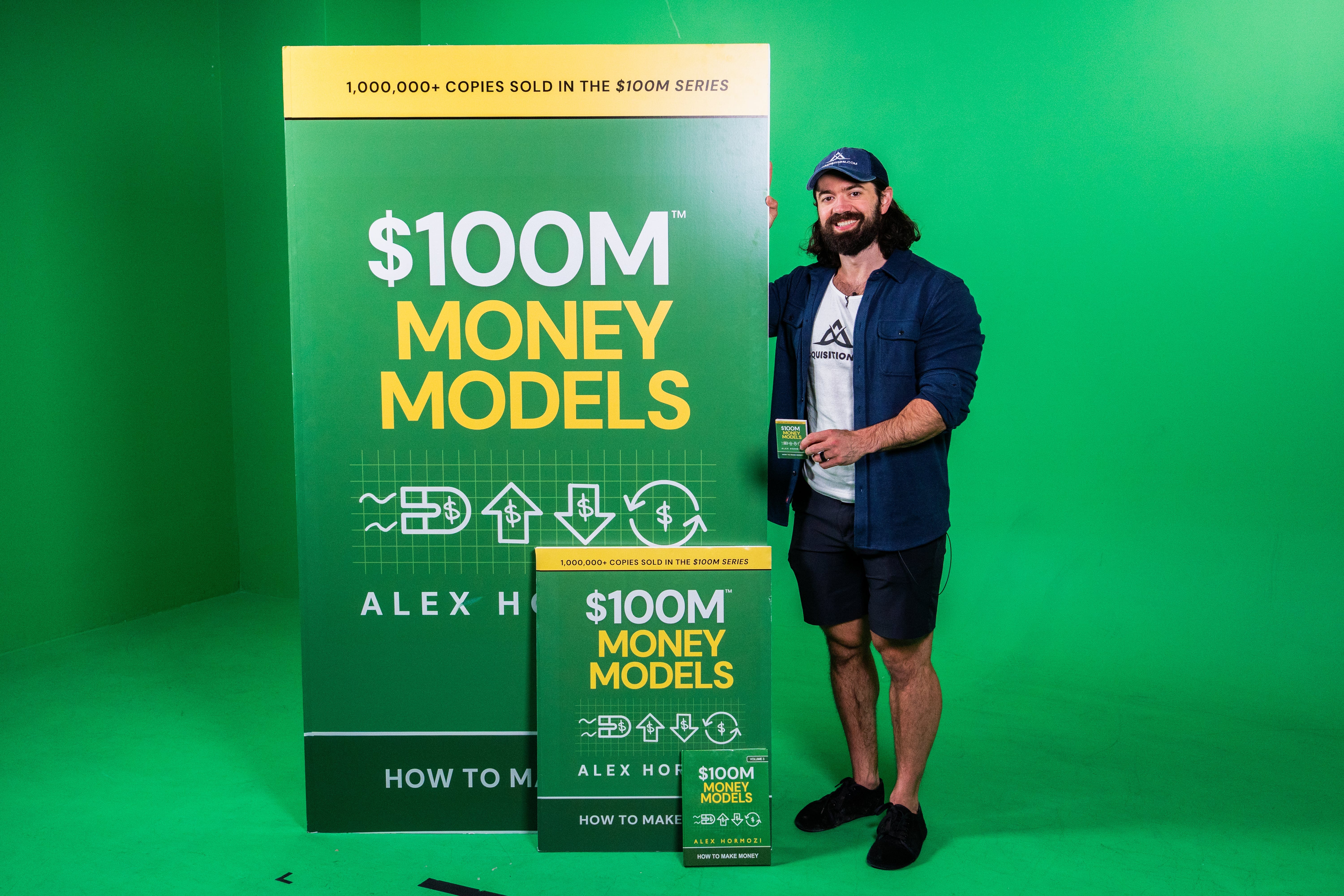 Alex Hormozi with his book